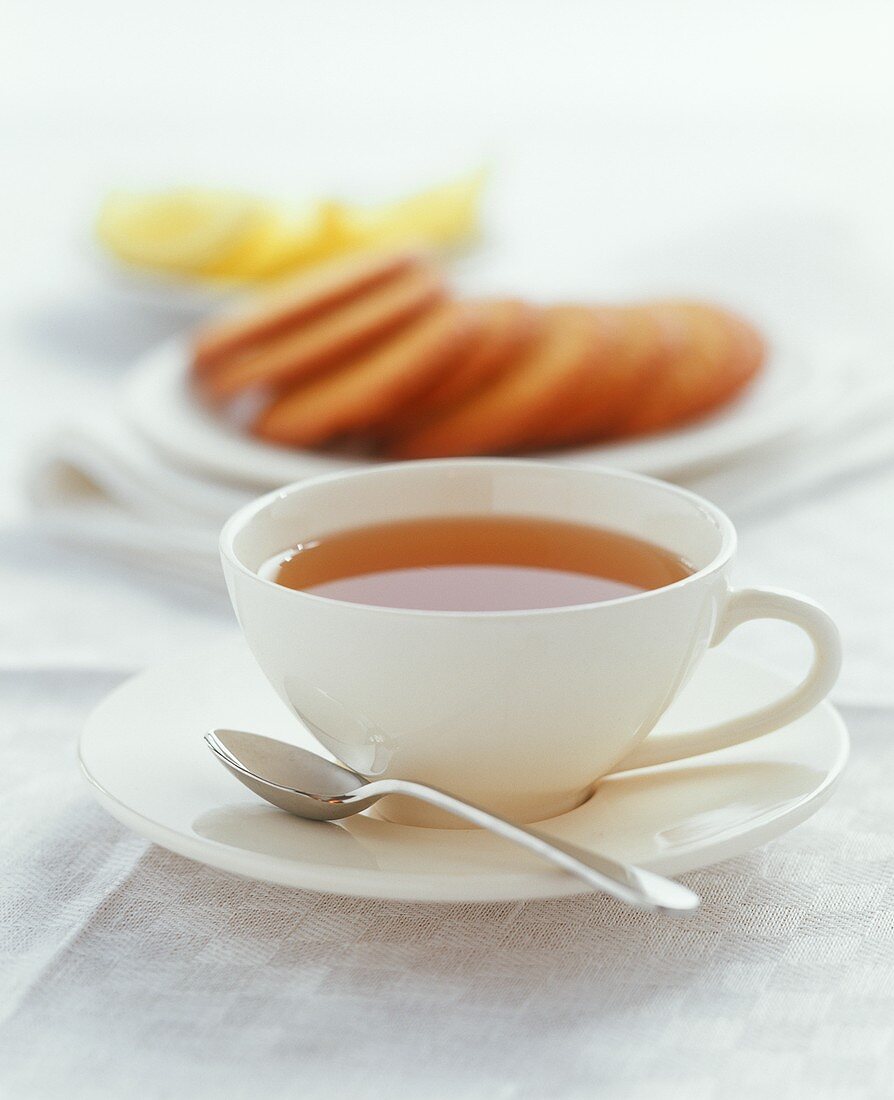 Tasse Tee mit Teegebäck im Hintergrund