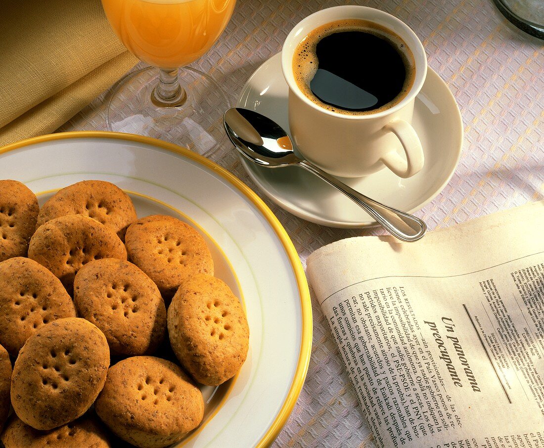 Plate of Spanish biscuits, newspaper, cup of coffee