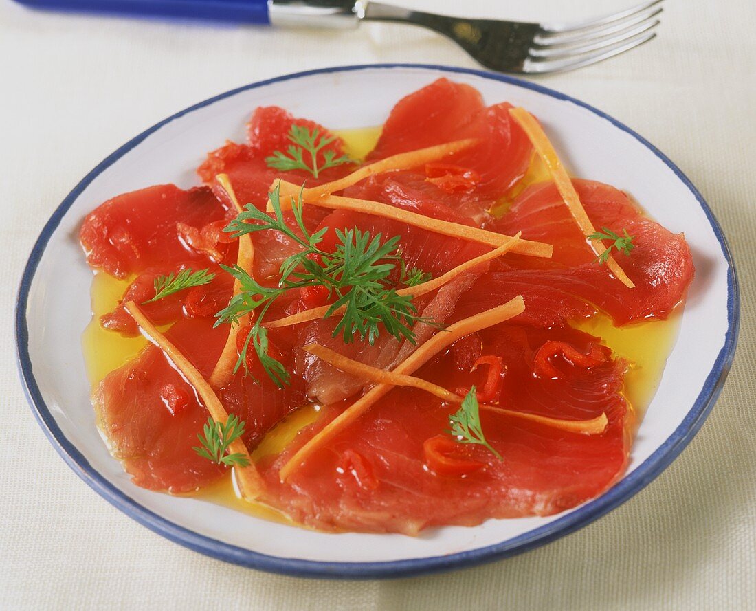 Tuna carpaccio in chili oil with strips of carrot