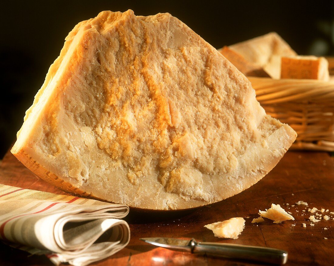 Stillleben mit grossem Stück Parmesan, davor Parmesanmesser