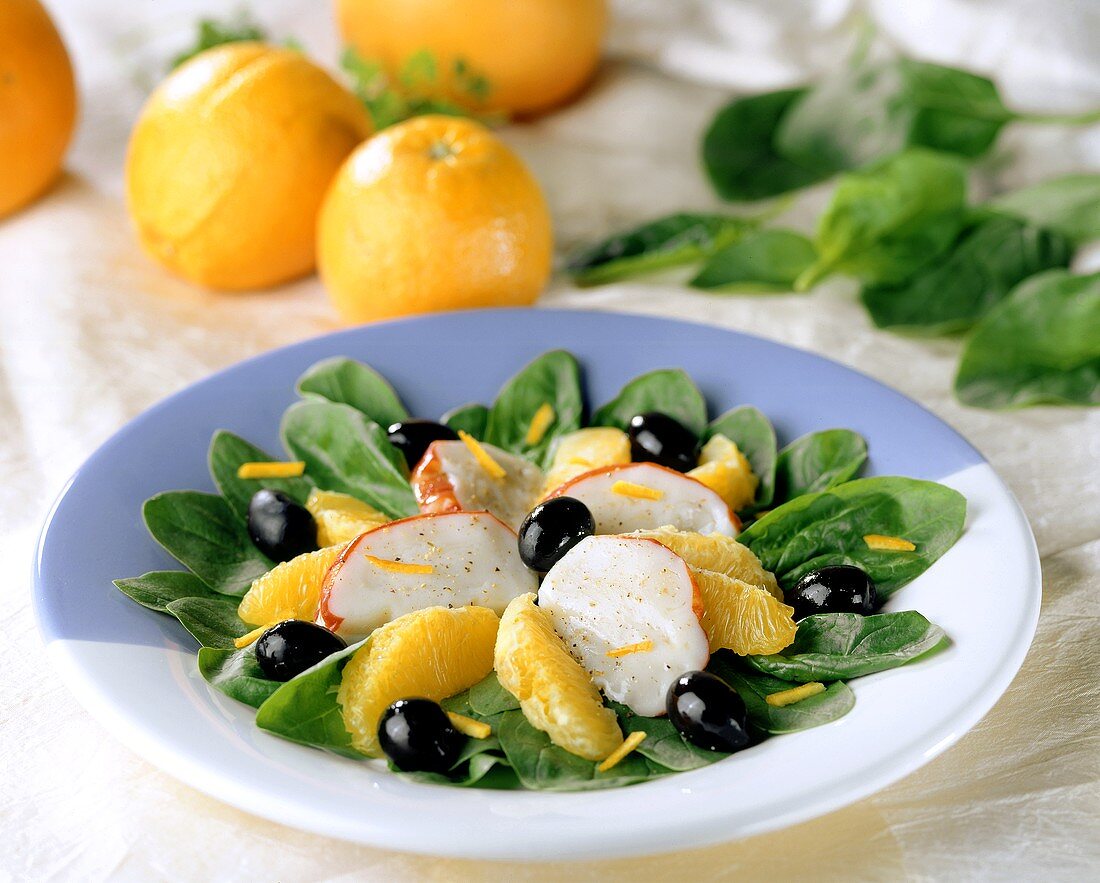 Spinach salad with orange wedges and langouste surimi