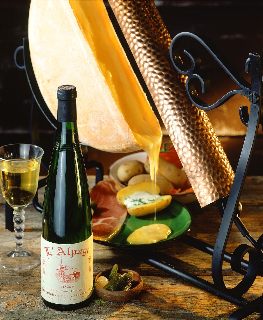 Traditionelles Raclette mit Flasche französischem Weißwein