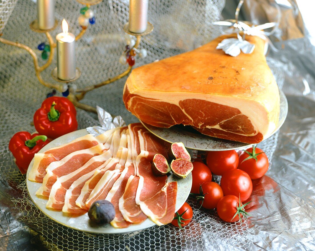 Whole air-dried ham, sliced on plate