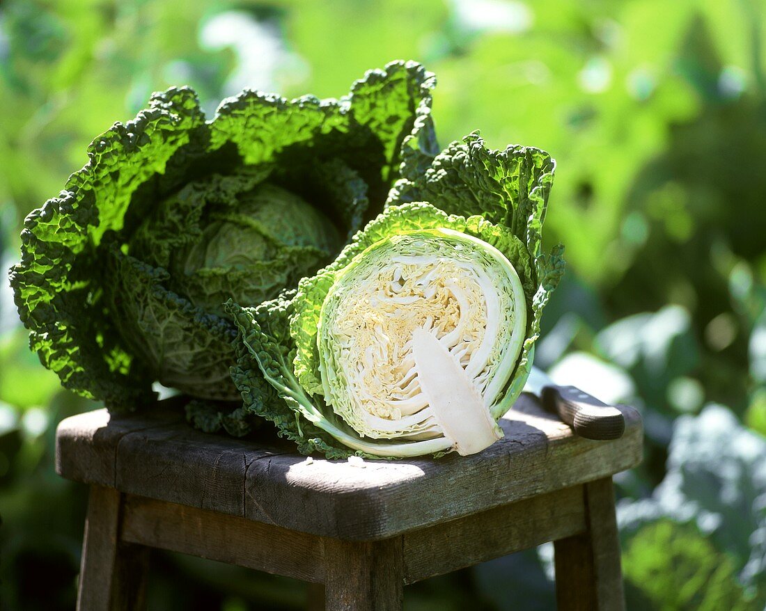 Half and whole fresh savoy on a wooden stool