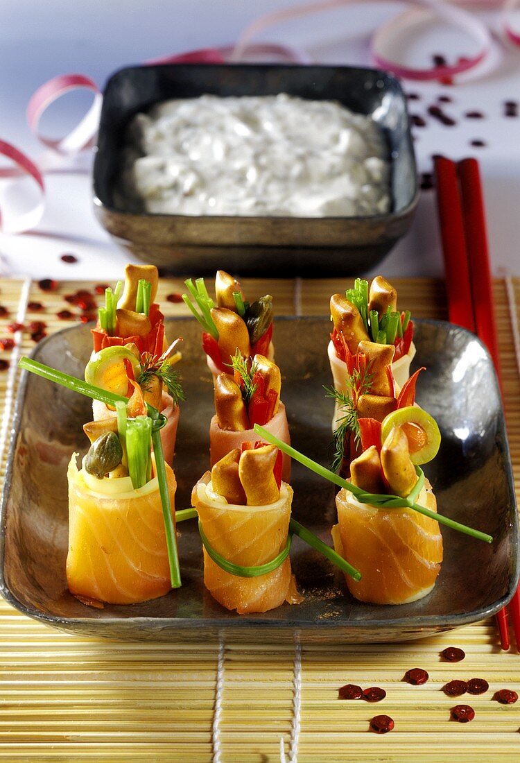 Colourful sushi-style salmon snacks, yoghurt dip behind
