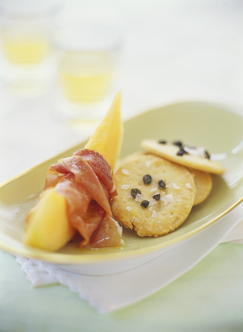 Honigmelone mit Schinken, dazu Parmesan-Kapern-Cracker