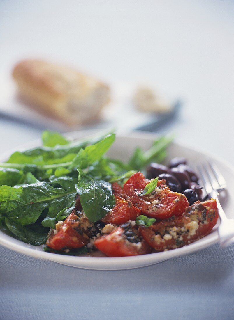 Toast with sheep's cheese, bottled tomatoes, olives, rocket