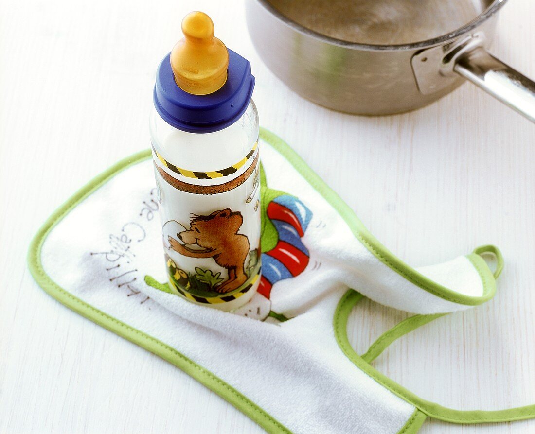 Baby milk in a baby’s bottle on bib