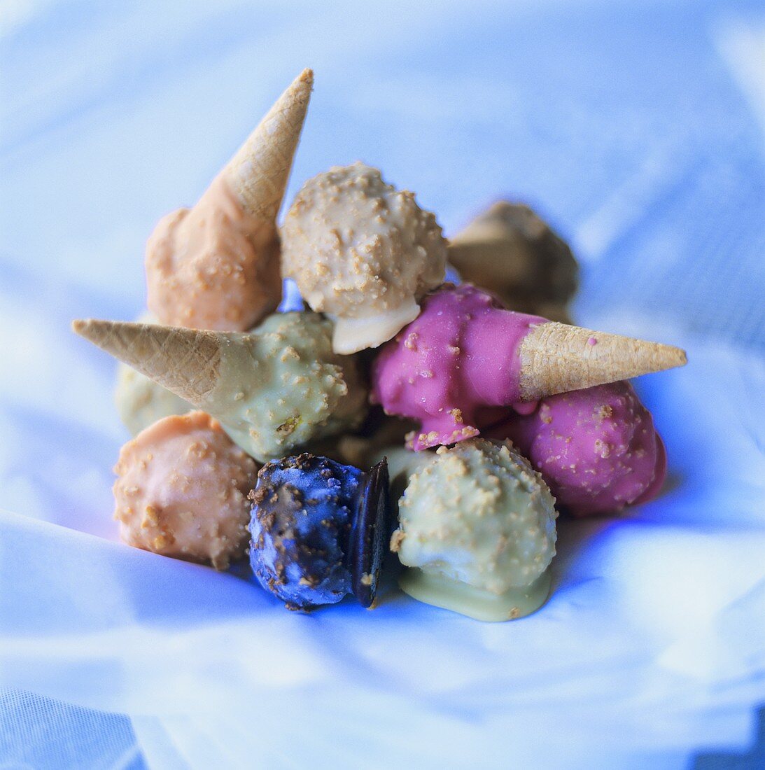 Chocolate-glazed ice cream cones in a pile