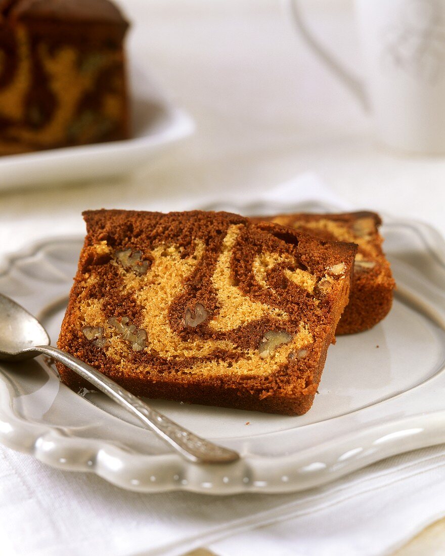 Two pieces of marble cake with pecans