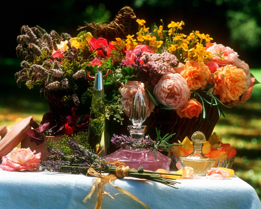 Stillleben mit Blumen und Duftwassern auf Tisch im Freien