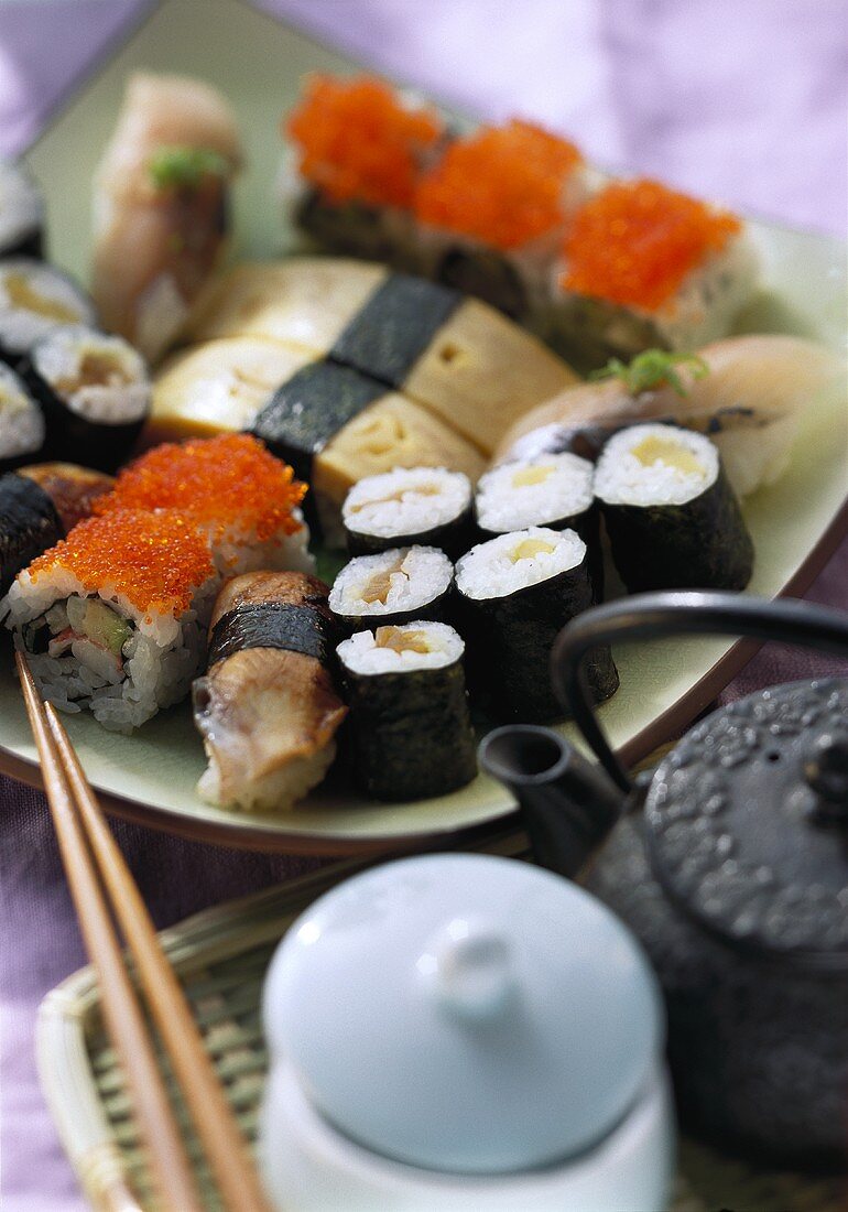 Assorted nigiri- and maki-sushi; teapot
