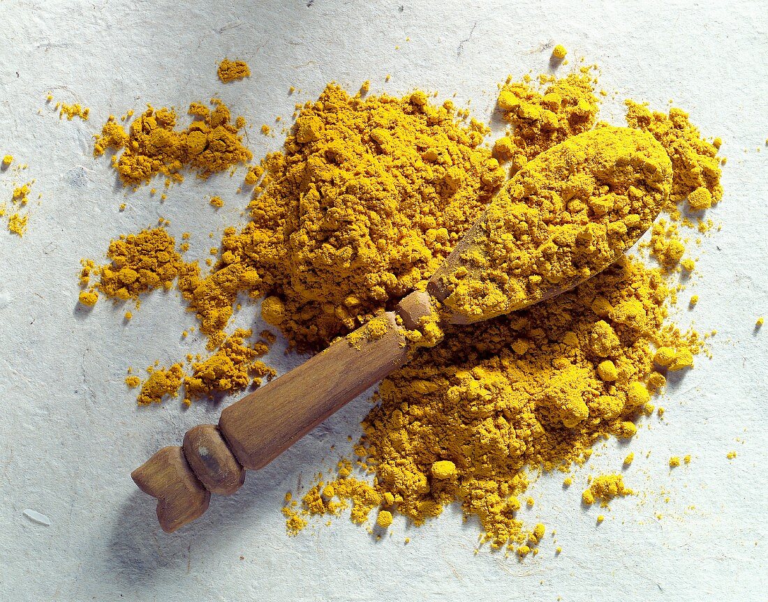 Ground turmeric with wooden spoon