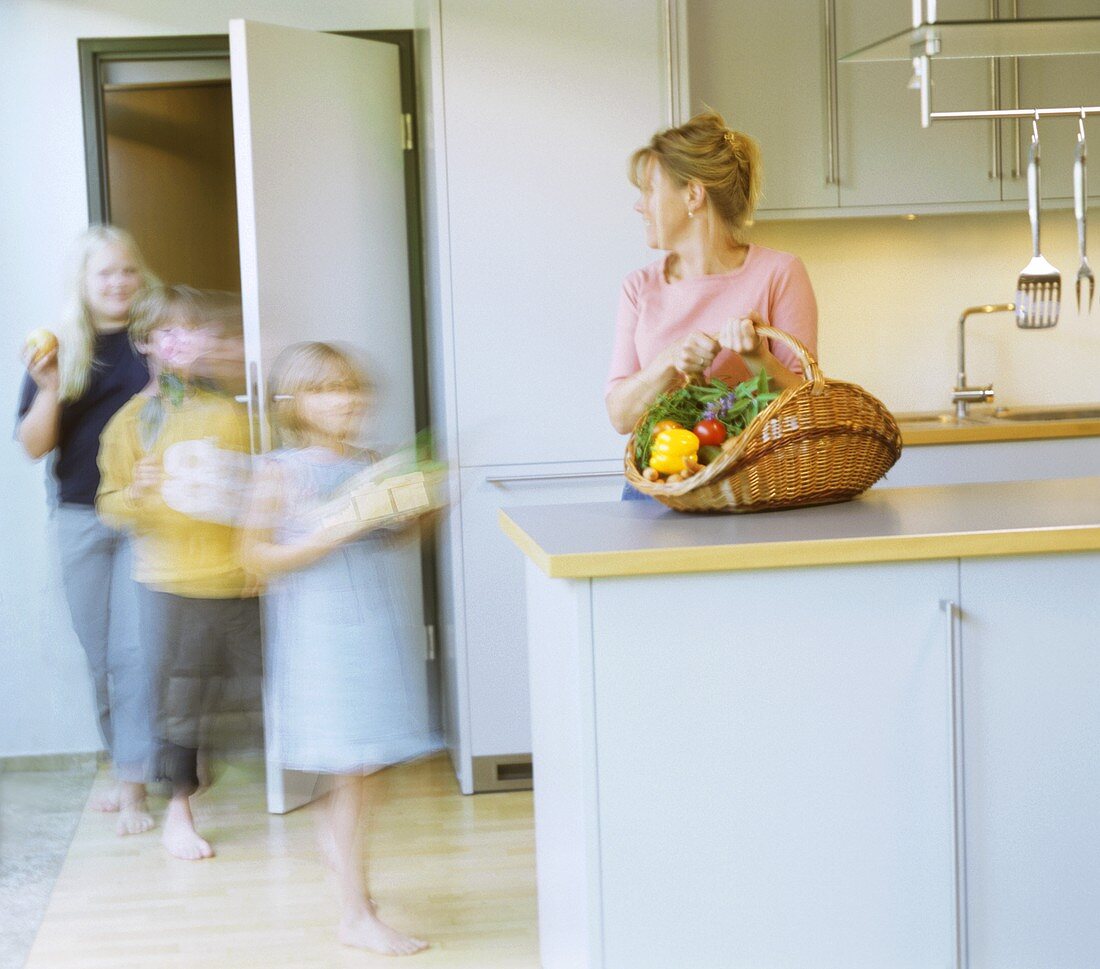 Mutter und Kinder kommen vom Einkauf heim