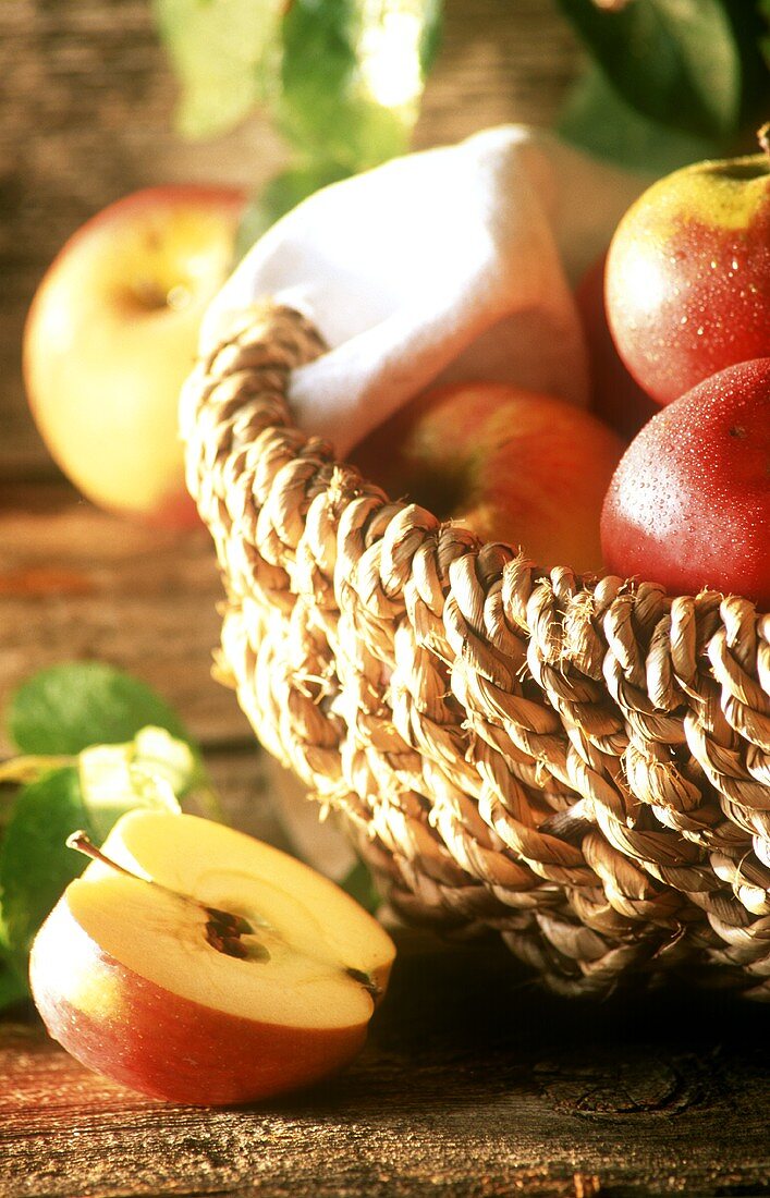 Organic apples in basket, half an apple beside it