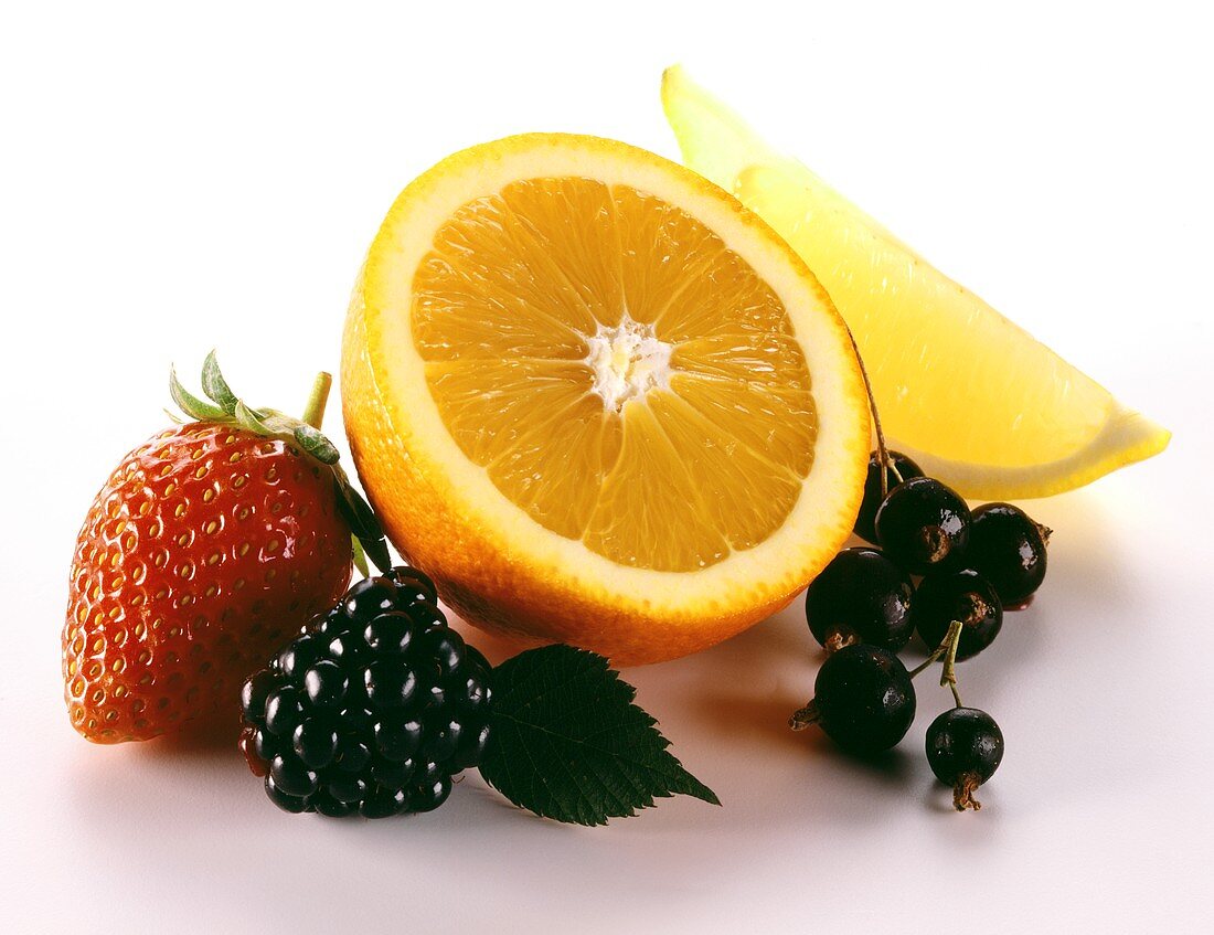 Still life with berries, half an orange and wedge of lemon