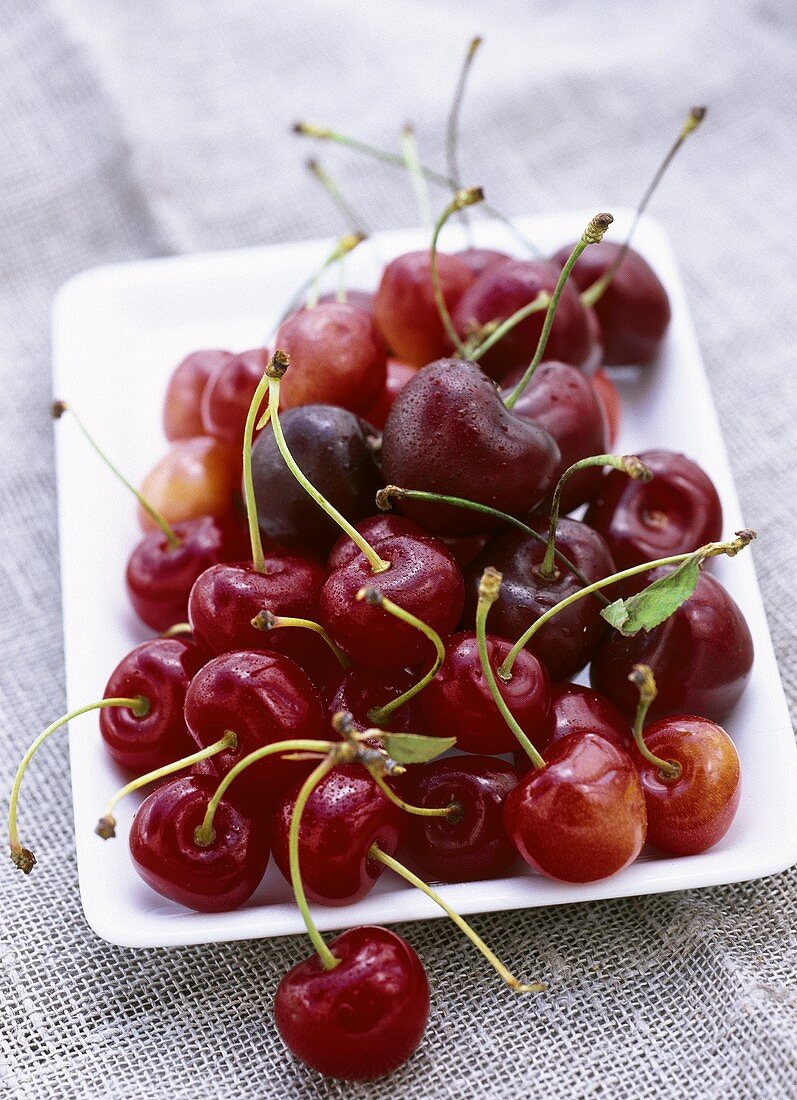 Various types of cherries on white platter
