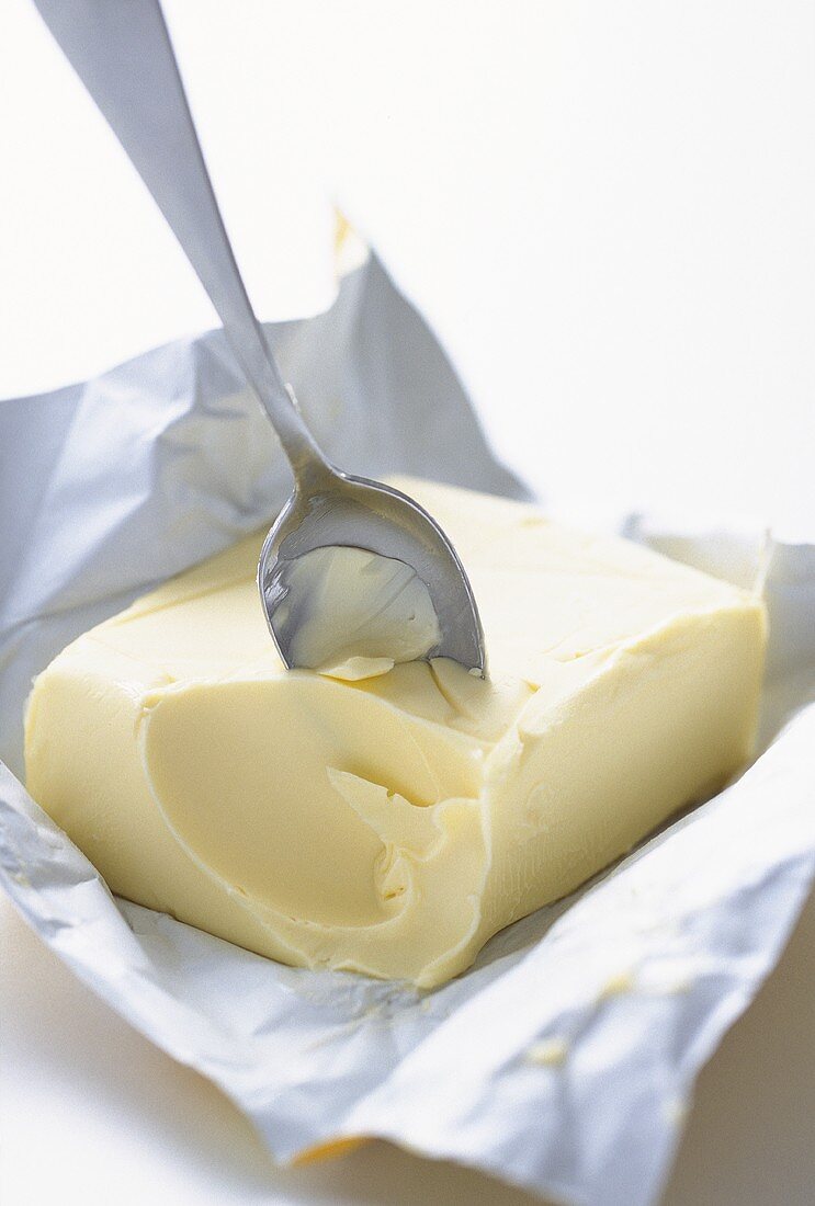 Esslöffel steckt in einem Stück Butter