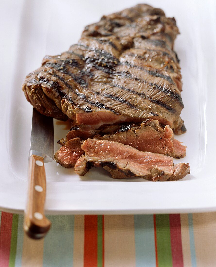 Barbecued leg of lamb, carved on platter