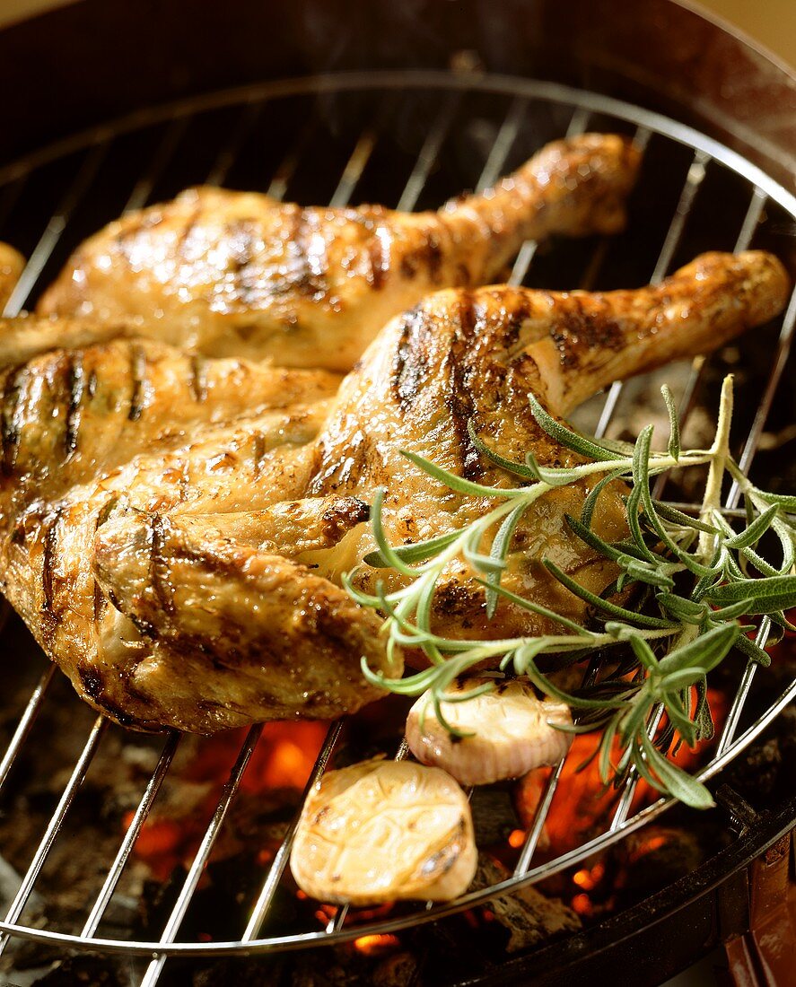 Whole chicken with herbs on barbecue