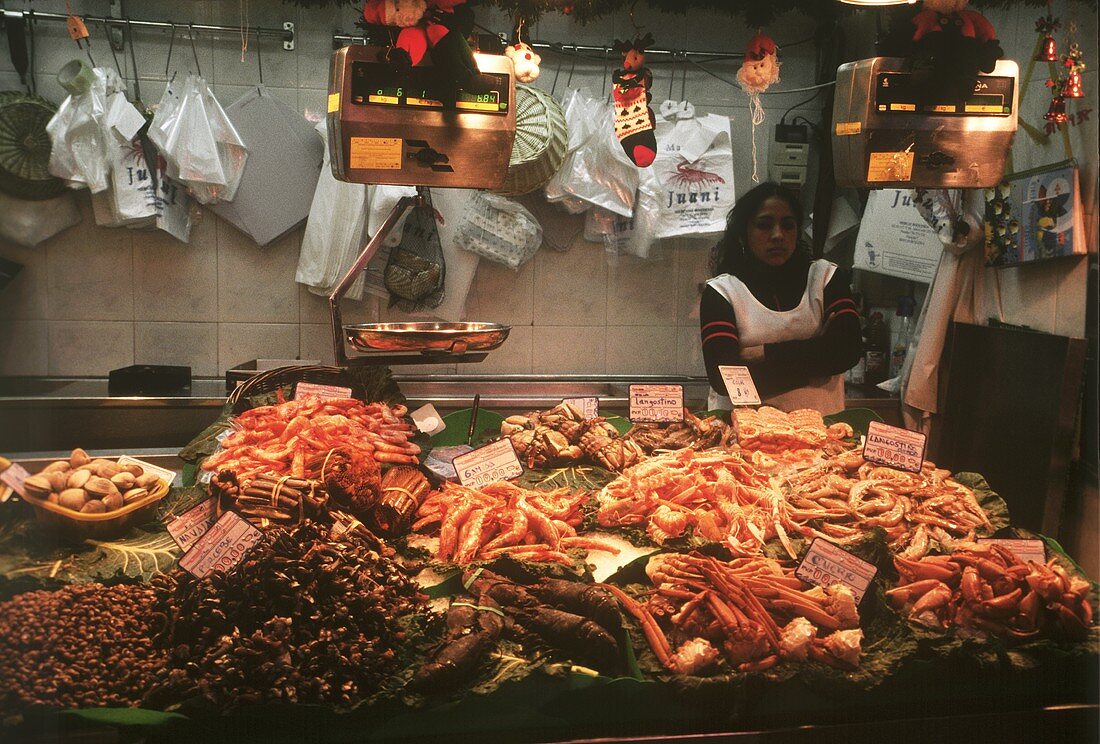 Frau in einem Verkaufsstand mit Meeresfrüchten und Muscheln
