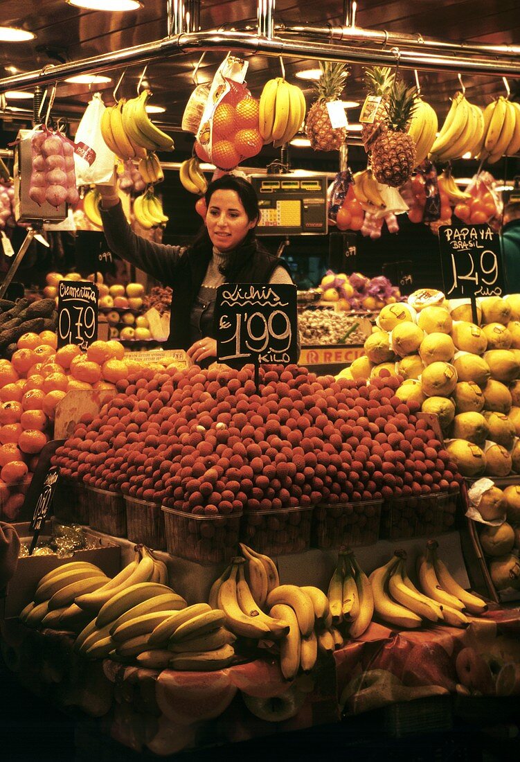 Verkäuferin an einem Obststand in der Boqueria in Barcelona