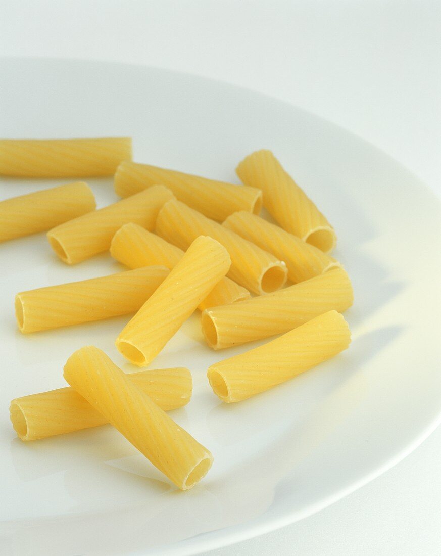 Uncooked rigatoni on white plate