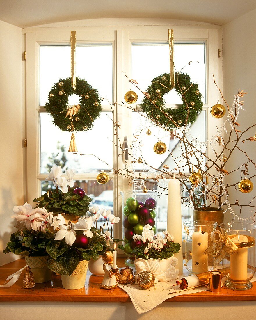 White Christmas window decoration with candles, plants etc.