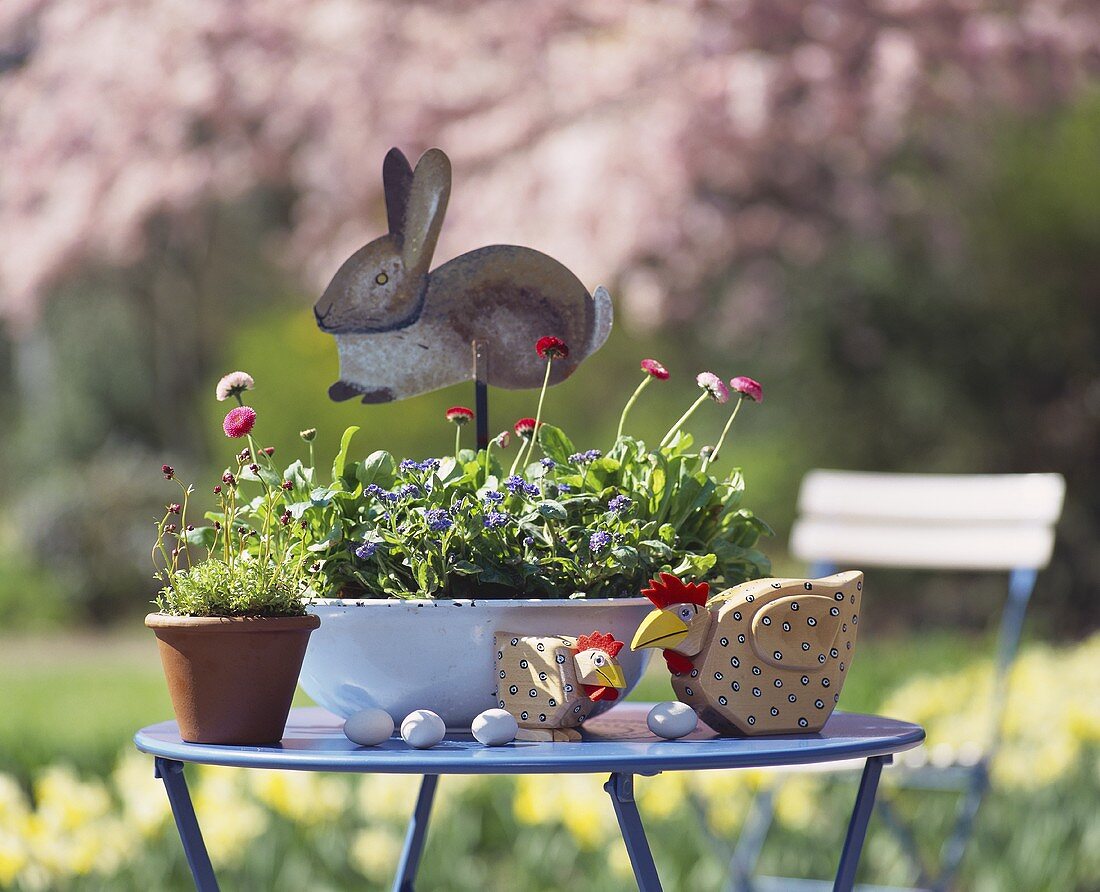 Blumentöpfe und Osterdeko auf Gartentisch