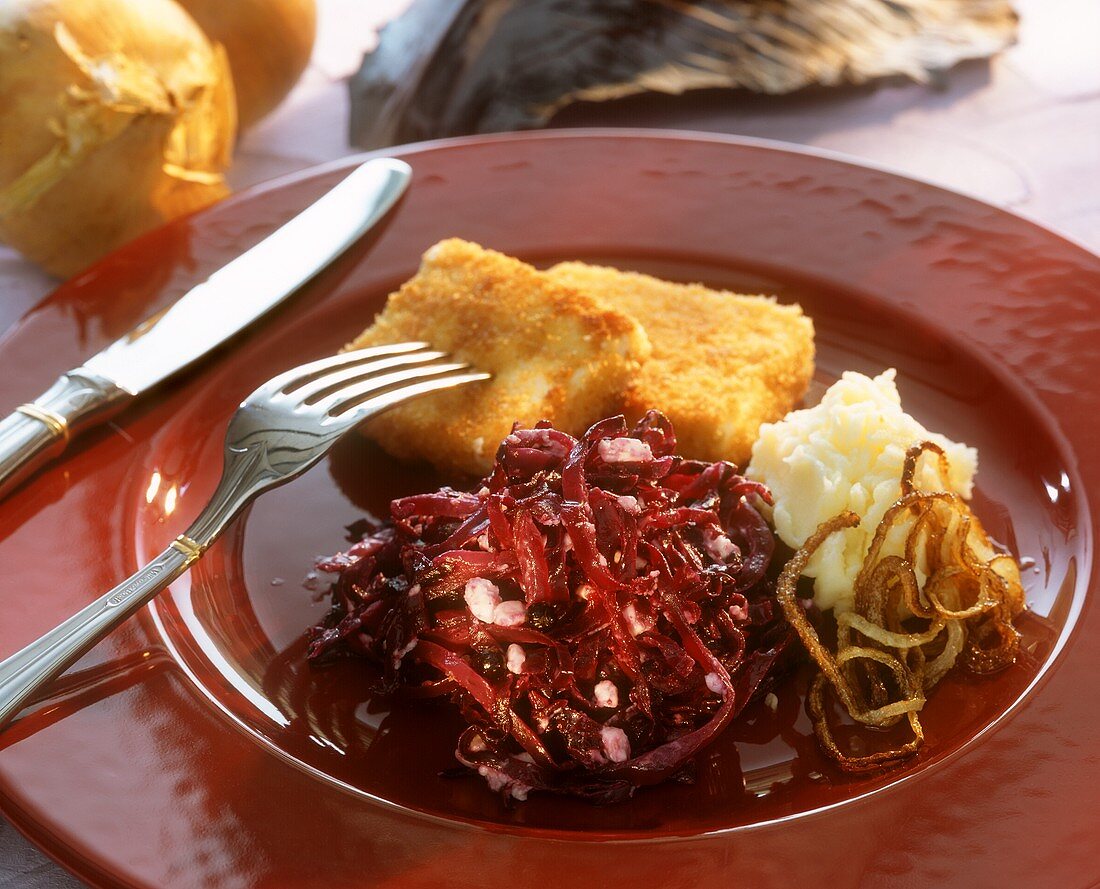 Breaded fish slices with red cabbage and mashed potato