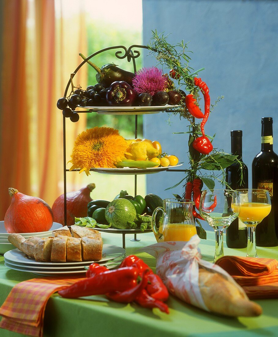 Tiered stand with vegetables and flowers on buffet table
