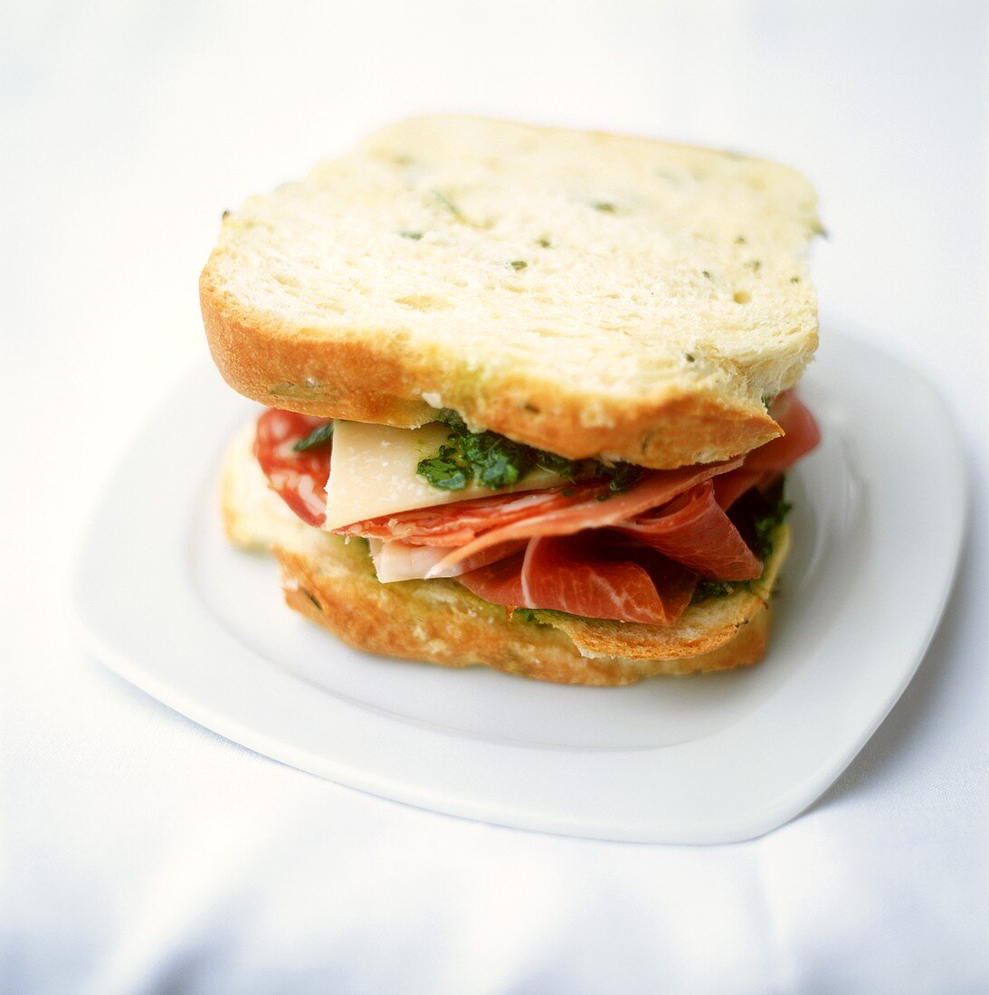 Italian sandwich with ham, salami, Parmesan and pesto