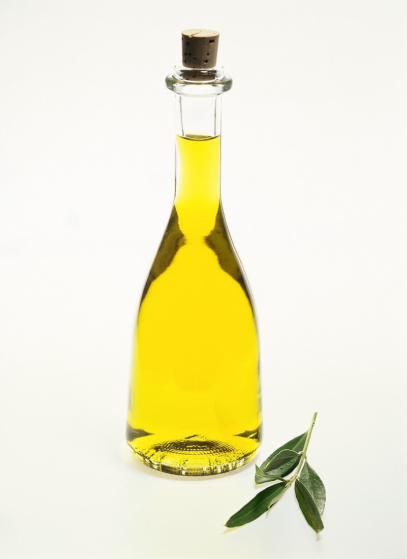 Olivenöl in Flasche mit Korken und Olivenzweig