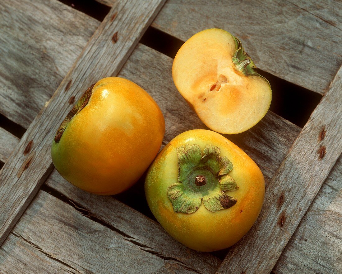 Two whole and one half sharon fruit (Sharon persimmon)