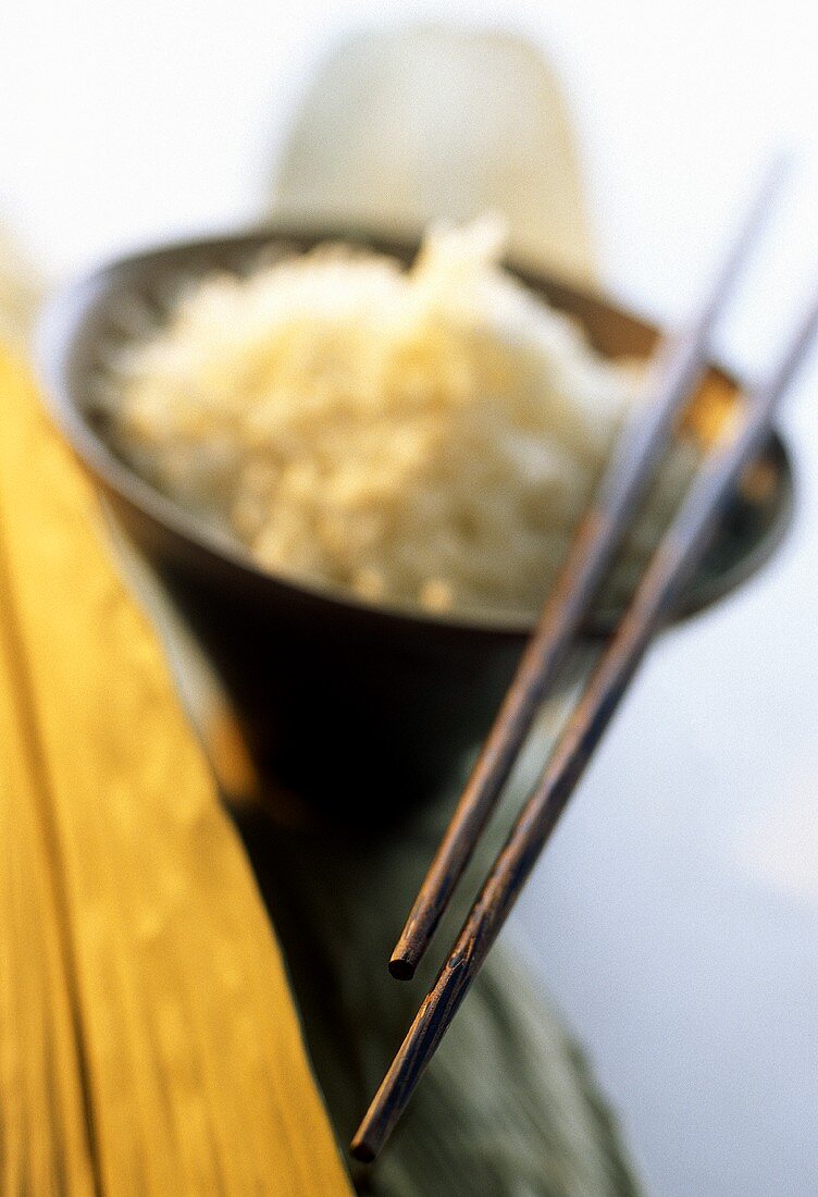 Stäbchen auf Holzschale mit gekochtem Reis