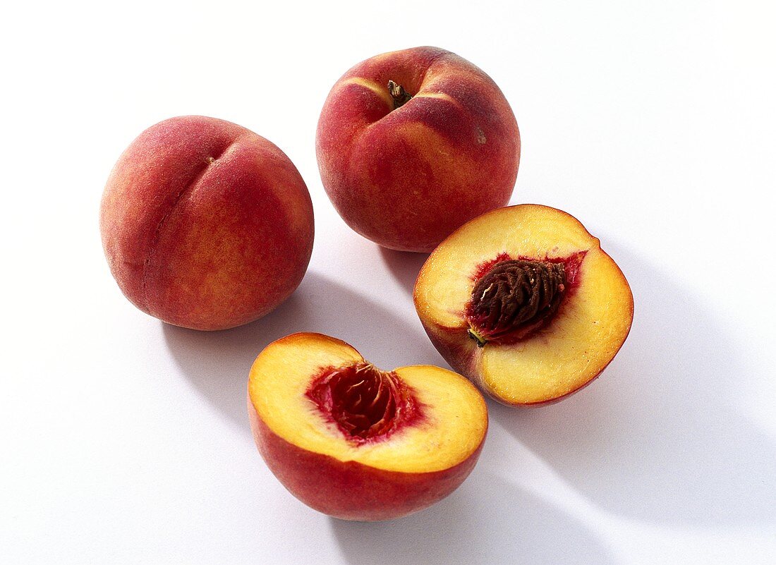Two whole and one halved peach
