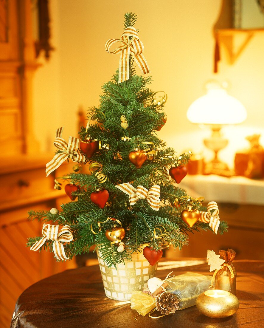 Kleiner Weihnachtsbaum und Geschenksäckchen auf einem Tisch