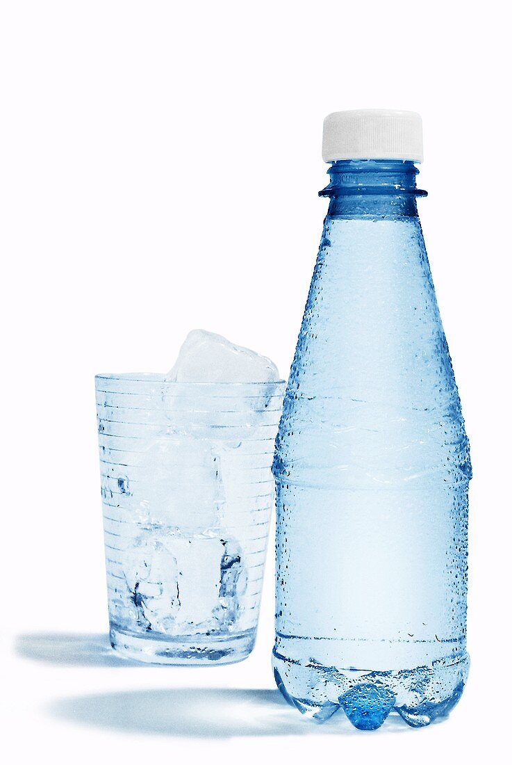 Eine Flasche Mineralwasser und ein Glas mit Eiswürfeln