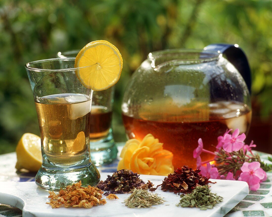 Iced herb tea with ingredients in open air