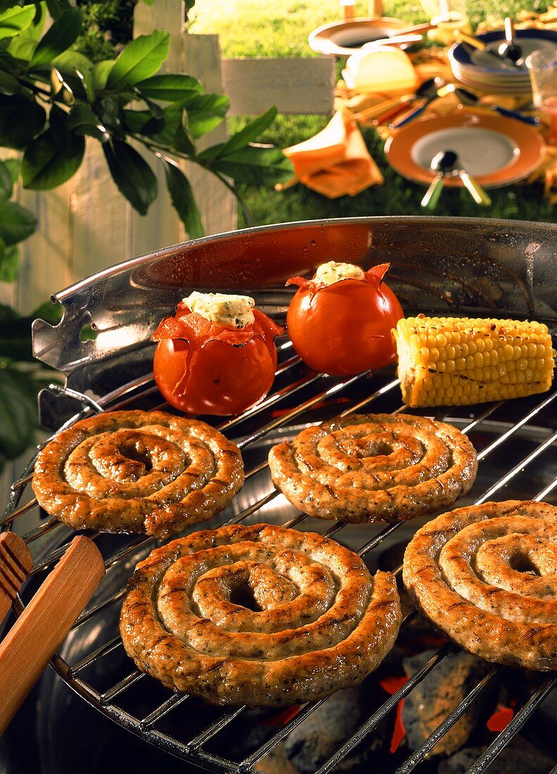 Barbecue scene with sausages and vegetables on the barbecue