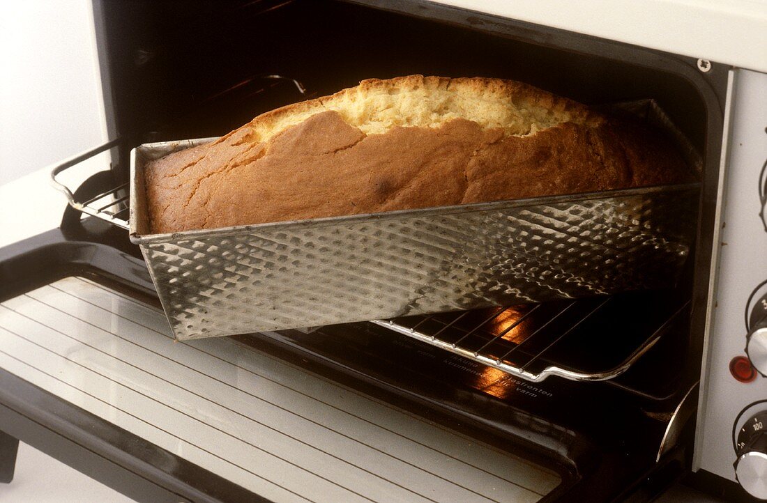 Taking loaf cake out of the oven