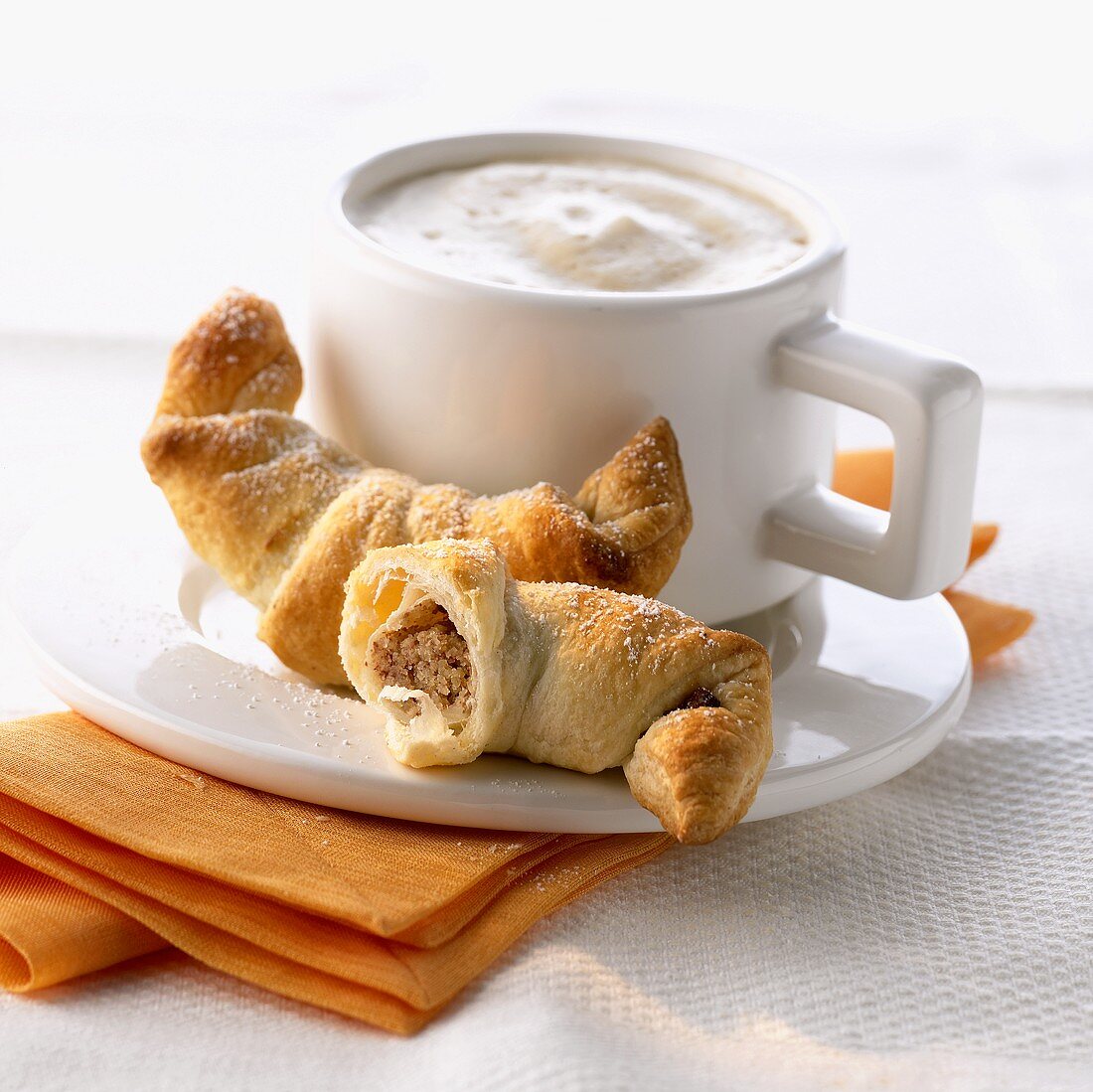Nut crescents and a cup of cappuccino