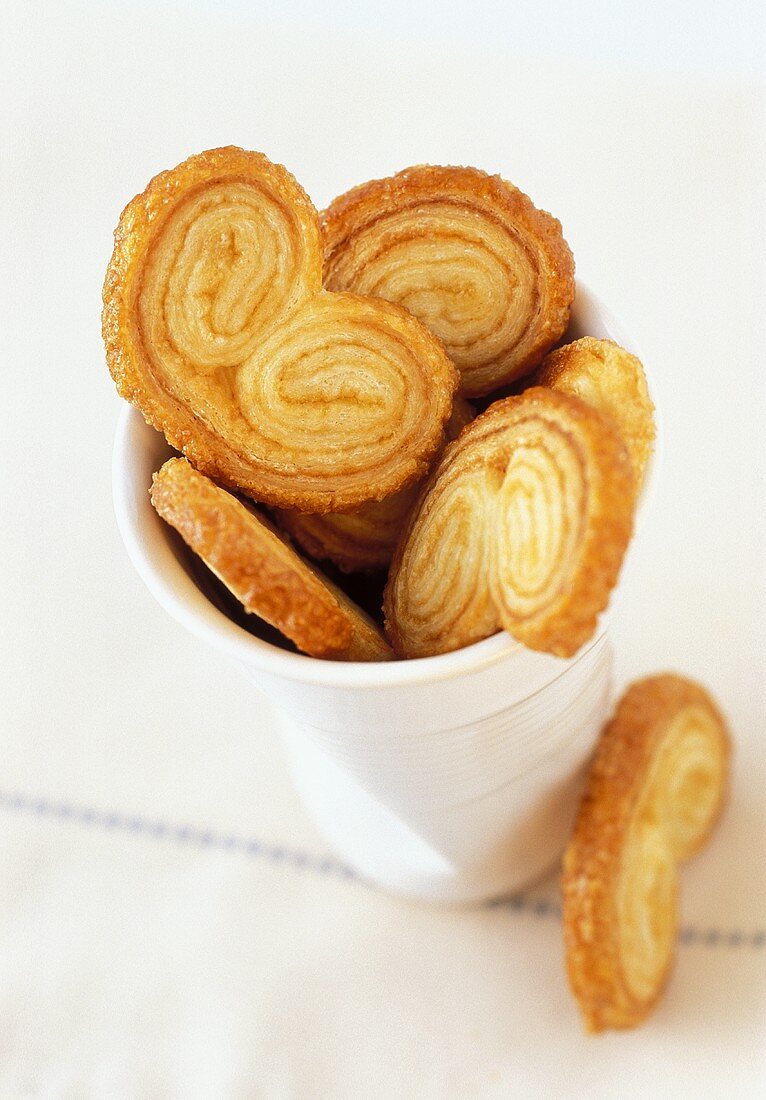 'Pig's ears' (puff pastries) in a beaker