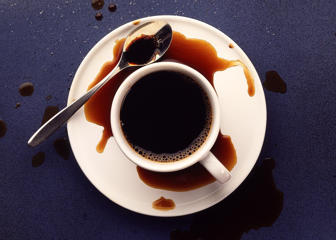 Eine Tasse Kaffee, teilweise ausgeschüttet