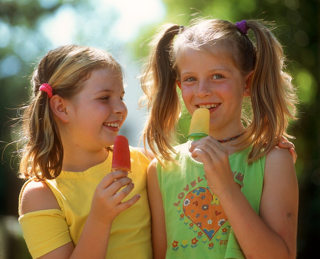 Two girls licking ice creams