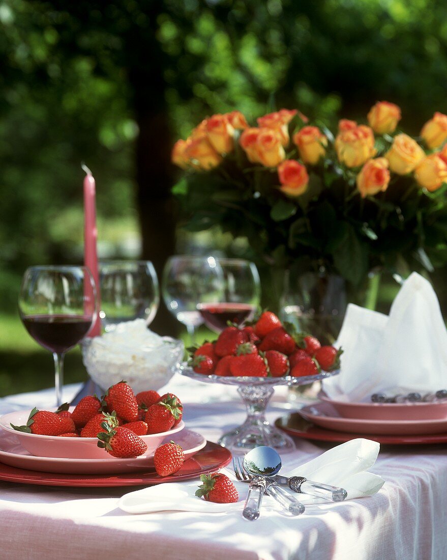 Gedeckter Tisch mit frischen Erdbeeren im Freien