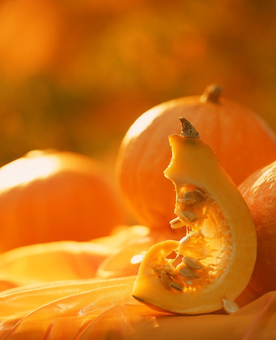 Wedge of pumpkin and whole pumpkins