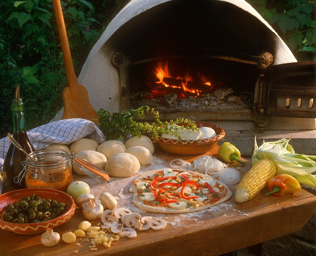 Unbaked pizza in front of pizza oven