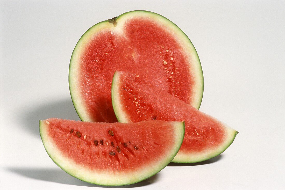Wassermelonenschnitze und Wassermelonenhälfte