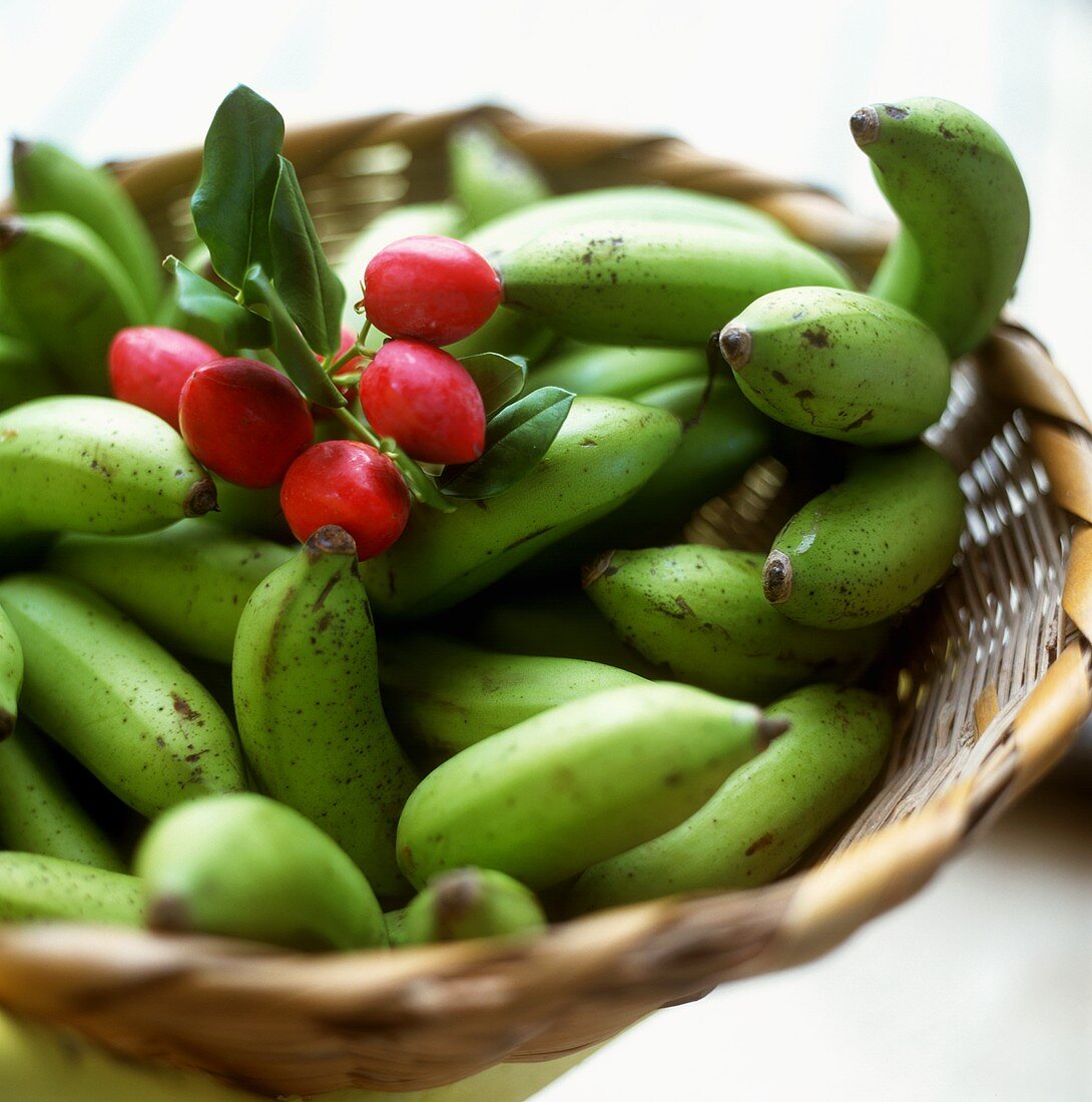 Grüne Bananen und rote Mandelfrüchte